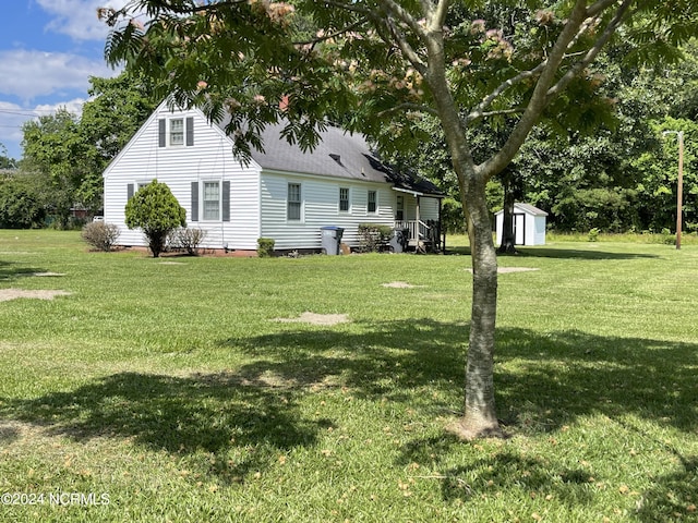 rear view of property featuring an outbuilding, crawl space, a lawn, and a shingled roof