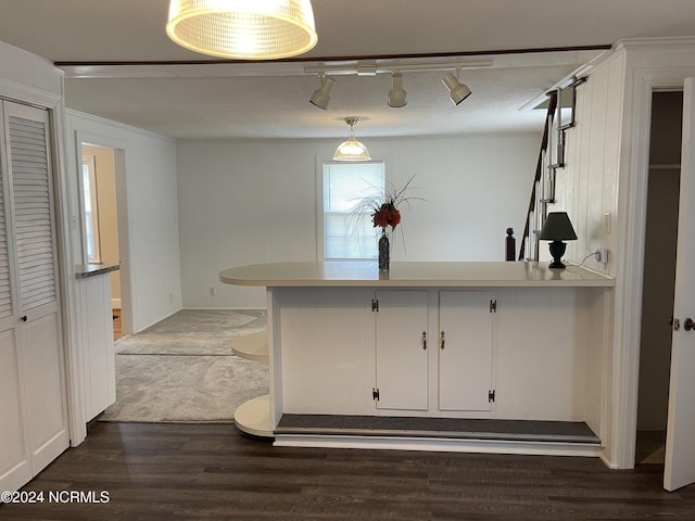 kitchen with dark wood-style floors, light countertops, white cabinetry, and a peninsula