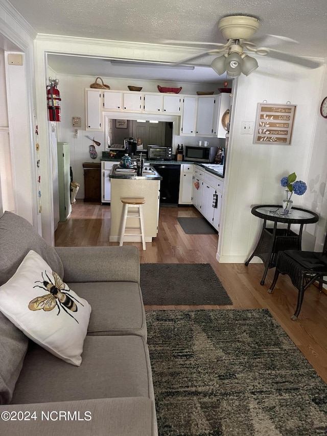 living room featuring a toaster, dark wood finished floors, a textured ceiling, and ceiling fan