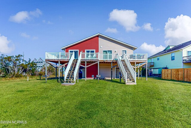 rear view of property with a lawn and a wooden deck