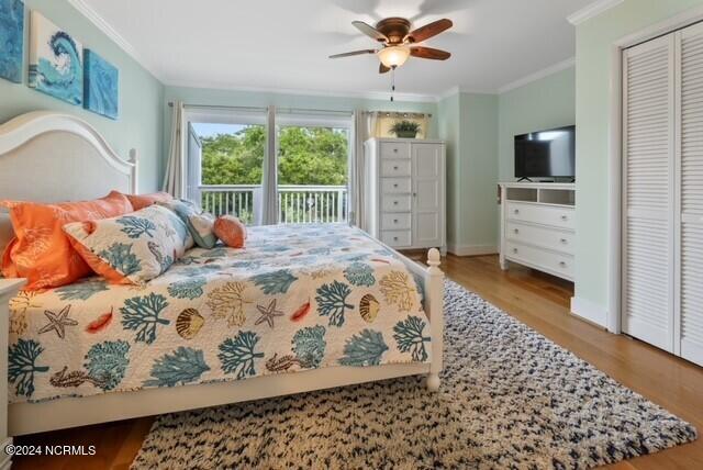 bedroom with a ceiling fan, crown molding, and wood finished floors