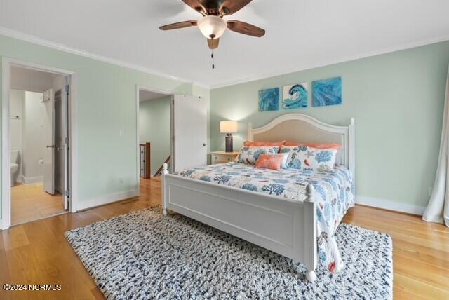 bedroom featuring crown molding, a ceiling fan, connected bathroom, wood finished floors, and baseboards