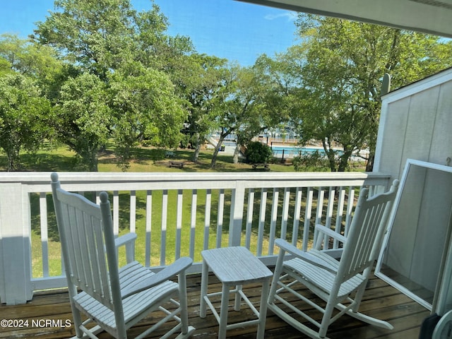 wooden terrace featuring a lawn