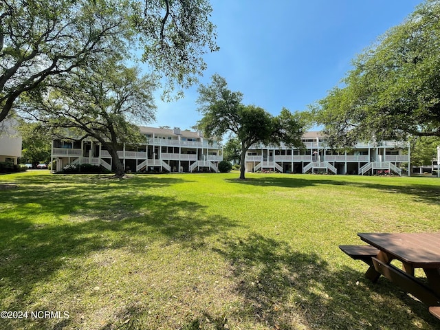 surrounding community featuring a deck, a lawn, and stairway