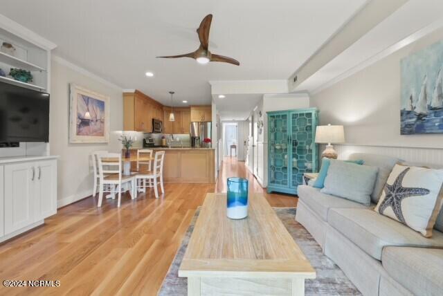 living area featuring recessed lighting, crown molding, light wood-style flooring, and ceiling fan