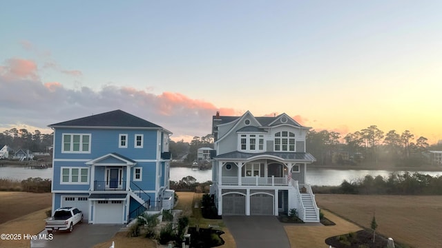 view of front of property featuring a water view, a porch, and a garage