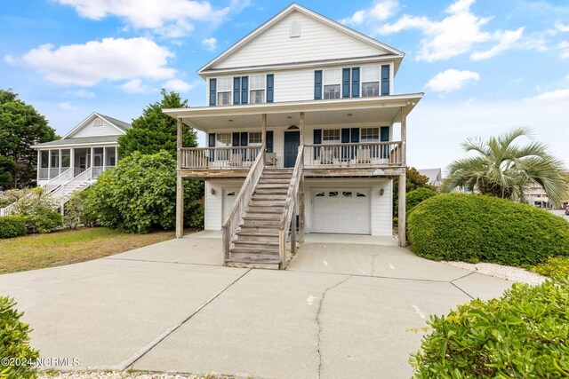 view of front of house featuring covered porch, a garage, and a sunroom