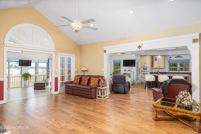 living room featuring light wood-type flooring, ceiling fan, and high vaulted ceiling