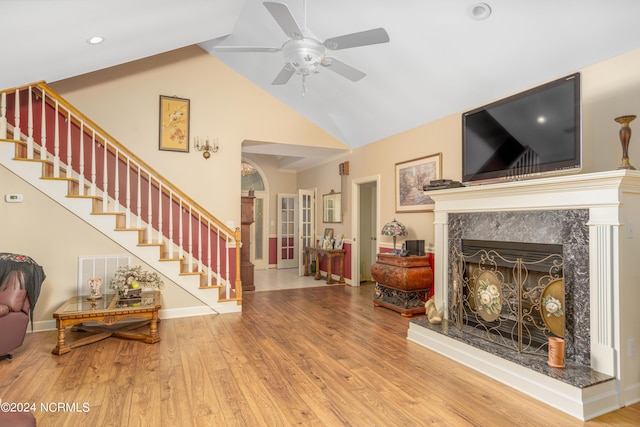 living room featuring ceiling fan, vaulted ceiling, a fireplace, and hardwood / wood-style flooring