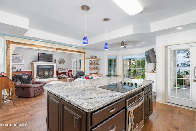 kitchen with ceiling fan, decorative light fixtures, dark brown cabinetry, stainless steel oven, and black electric cooktop