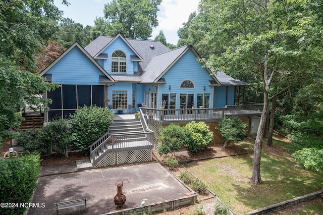 back of house featuring a wooden deck and a sunroom