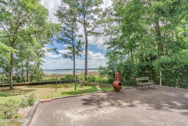 view of home's community featuring a lawn and a water view