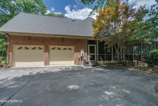 front of property with a garage and a sunroom