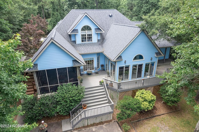 rear view of house with a wooden deck and a sunroom