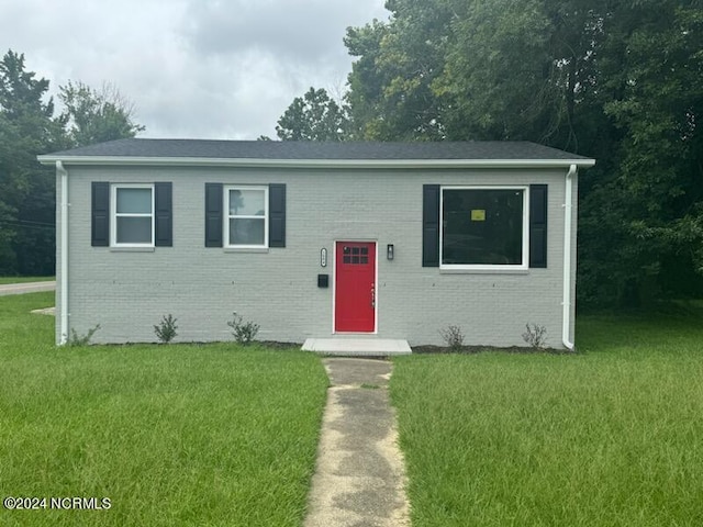 view of front of home featuring a front yard and brick siding