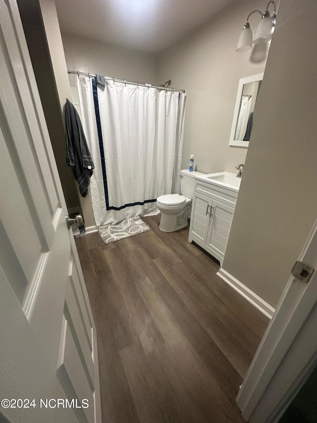 bathroom featuring vanity, hardwood / wood-style flooring, and toilet