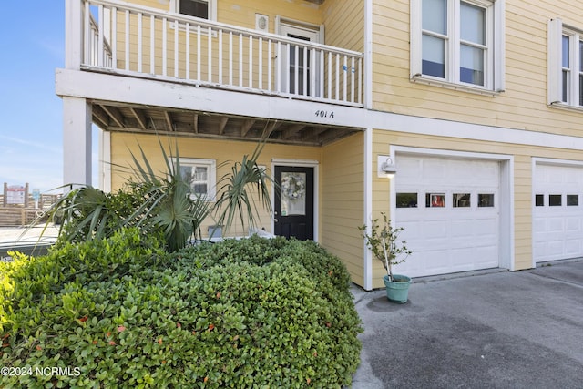 doorway to property with a balcony and a garage