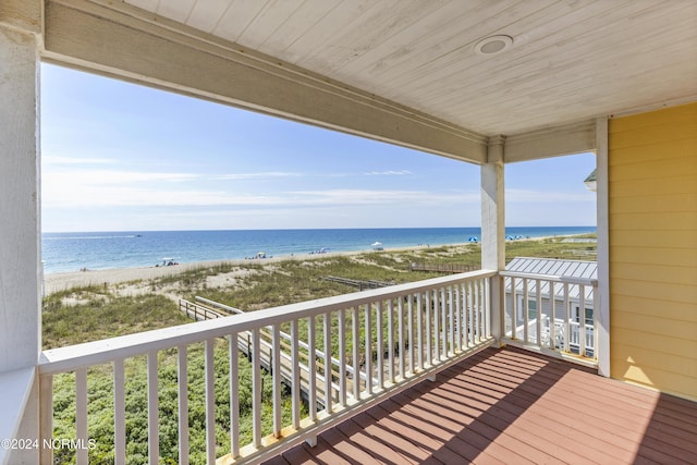 wooden terrace featuring a view of the beach and a water view