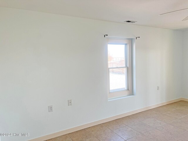 unfurnished room featuring light tile patterned floors and ceiling fan