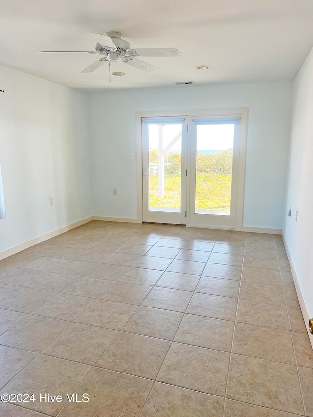 spare room with ceiling fan and light tile patterned flooring