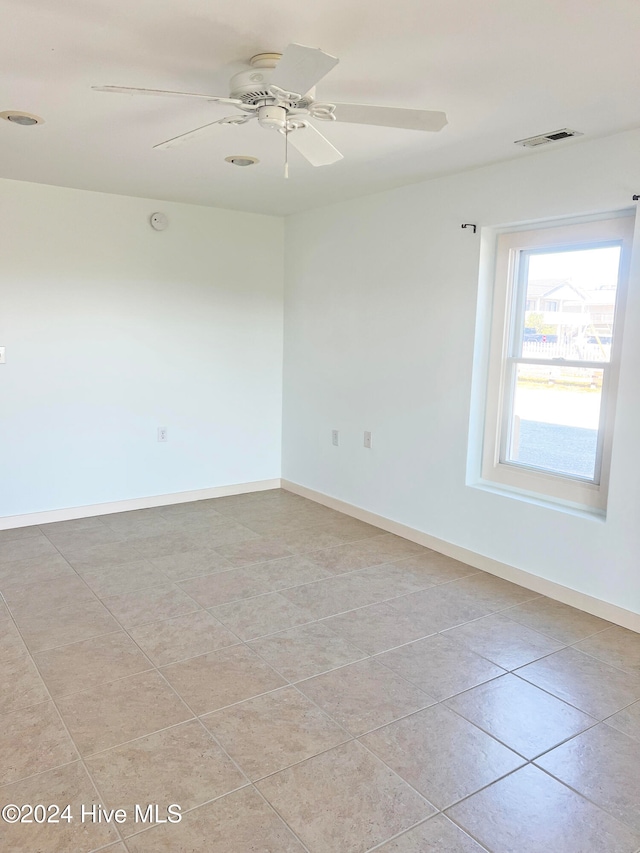 tiled spare room featuring ceiling fan