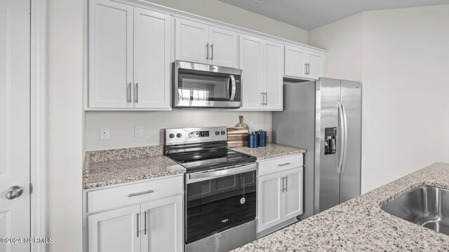 kitchen featuring white cabinetry, light stone countertops, sink, and stainless steel appliances