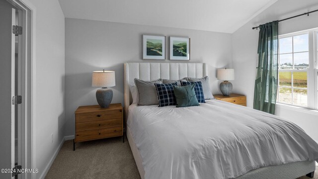 carpeted bedroom with lofted ceiling