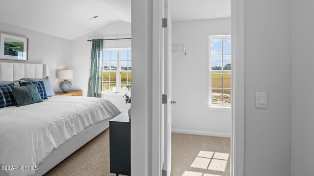 bedroom with light carpet and vaulted ceiling