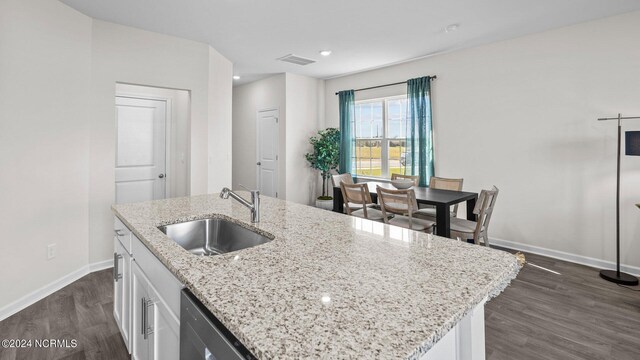 kitchen featuring a kitchen island with sink, dark wood-type flooring, sink, and white cabinetry