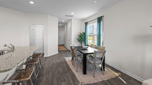 dining area featuring sink and dark wood-type flooring