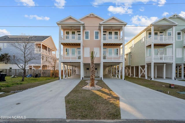 coastal home featuring a front lawn and a carport