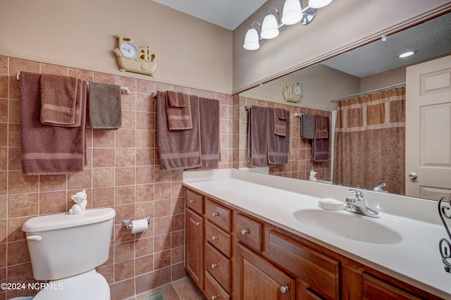 bathroom with vanity, toilet, tile walls, and walk in shower