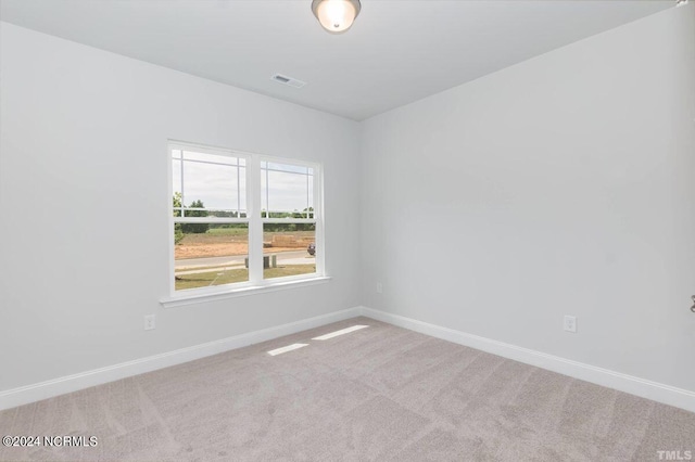 spare room featuring light carpet, baseboards, and visible vents