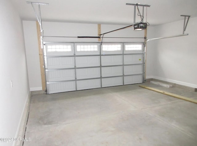 garage with a garage door opener and baseboards