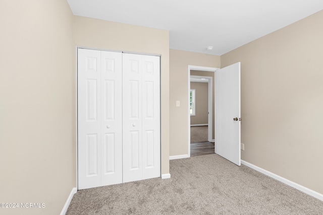 unfurnished bedroom with a closet and carpet floors