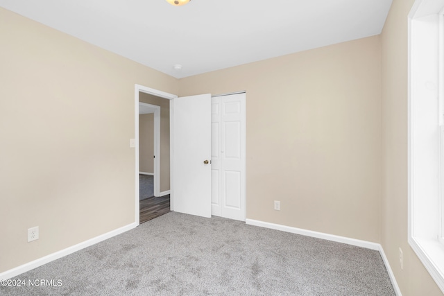 unfurnished bedroom with a closet and carpet floors