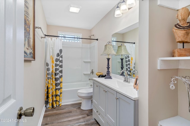 full bathroom featuring vanity with extensive cabinet space, toilet, hardwood / wood-style flooring, and shower / bathtub combination with curtain