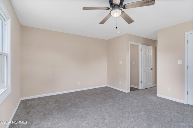 carpeted spare room featuring ceiling fan