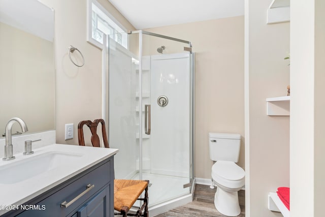 bathroom with a shower with shower door, toilet, vanity, and hardwood / wood-style flooring