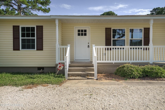 entrance to property with crawl space and a porch