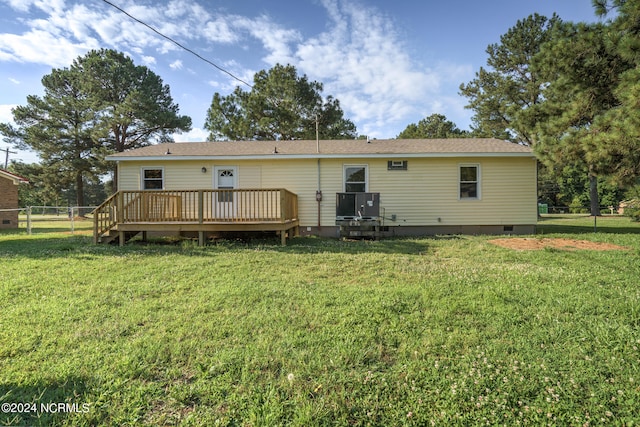 back of property with a deck and a lawn