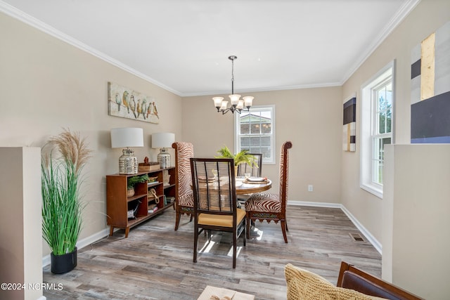 dining space featuring a wealth of natural light, hardwood / wood-style floors, a chandelier, and ornamental molding