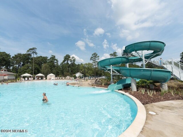 view of swimming pool with a water slide