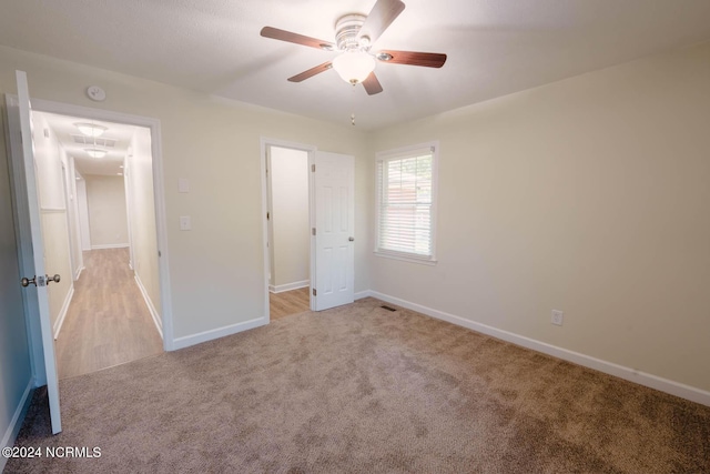 unfurnished bedroom with light colored carpet and ceiling fan