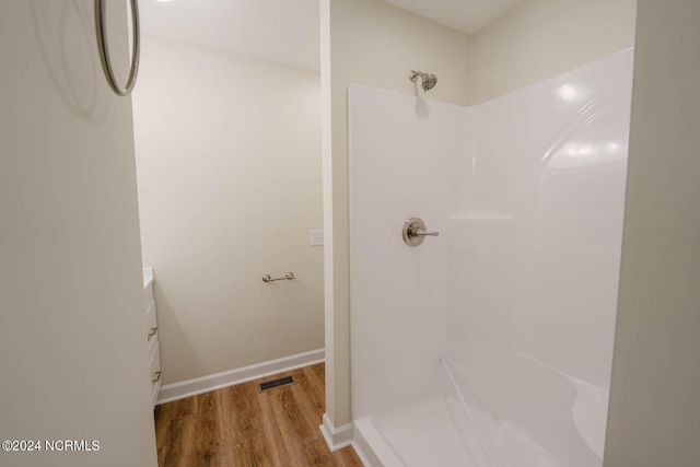 bathroom with a shower, vanity, and wood-type flooring