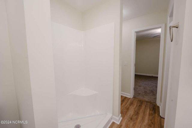 bathroom with hardwood / wood-style flooring and walk in shower