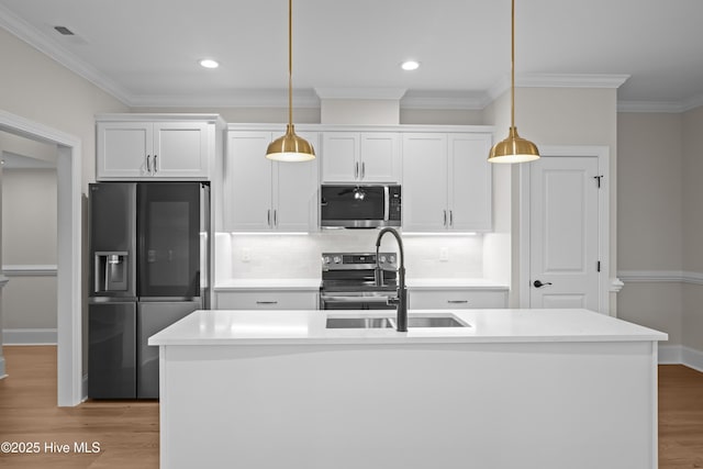 kitchen with decorative backsplash, light wood-style flooring, appliances with stainless steel finishes, decorative light fixtures, and a sink