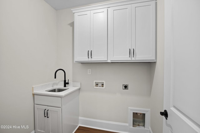 washroom with washer hookup, cabinet space, a sink, electric dryer hookup, and baseboards