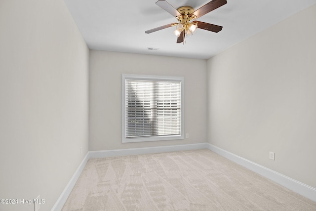 empty room featuring visible vents, ceiling fan, light carpet, and baseboards