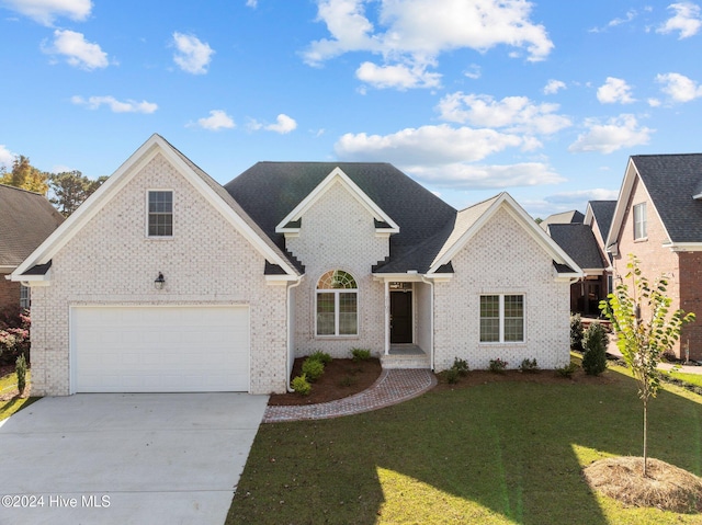 view of front of home with a garage, a front yard, concrete driveway, and brick siding